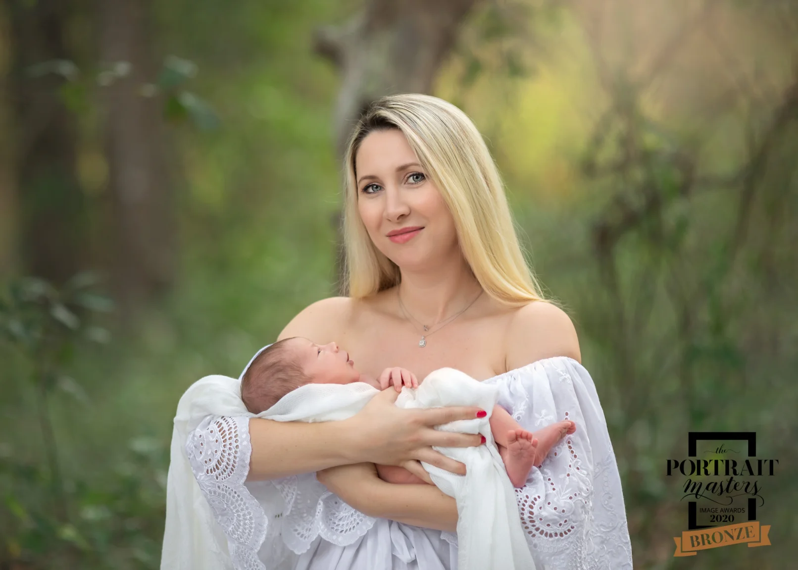 mother holding her newborn in woods