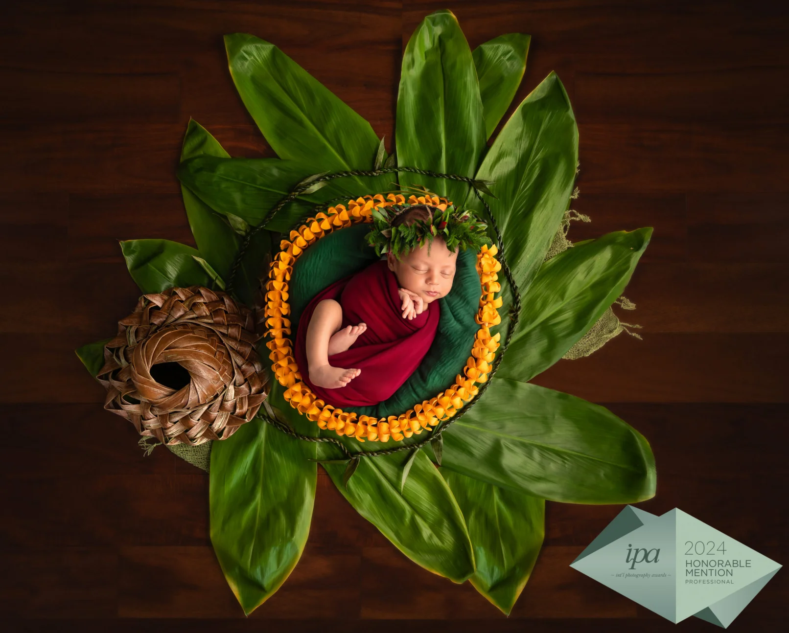 newborn baby boy with Hawaiian props and yellow flower necklace